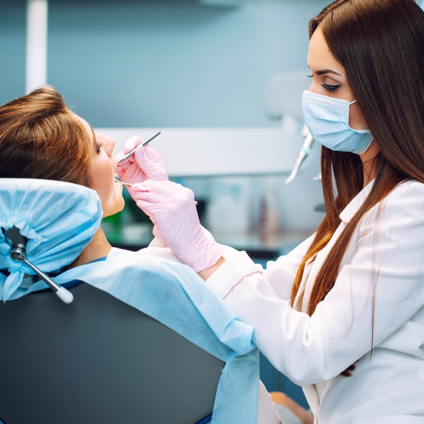 Dentist performing an oral cancer screening | Kokua Smiles